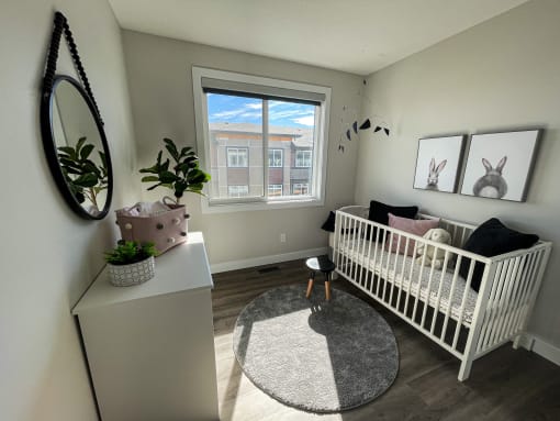 a nursery with a crib and a dresser and a window