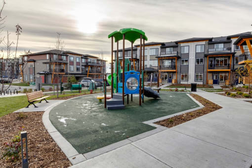 a playground in a park with apartments in the background