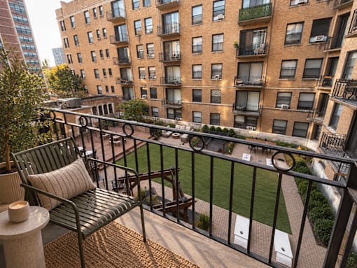 A balcony with a bench and a table with candles on it.