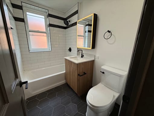 A bathroom with a toilet, sink, and mirror.