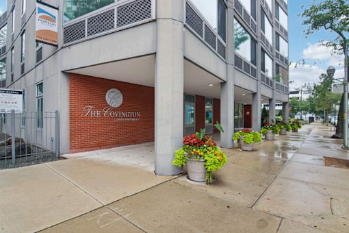 The Covington building is a low-rise structure with a red brick wall and a sign on the front.