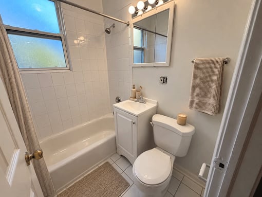 A bathroom with a toilet, sink, and bathtub.