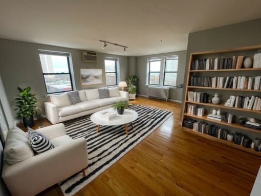 a living room with white furniture and a striped rug
