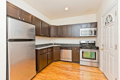 A kitchen with wooden floors and a white door.