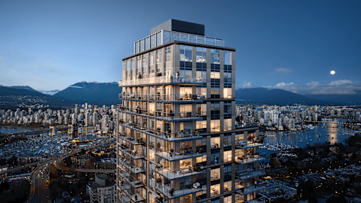 A tall, modern building with many windows is lit up at night.