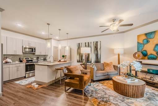 A modern kitchen with a dining area and a living room at Atlas Point at Prestonwood Apartments , Carrollton, 75010