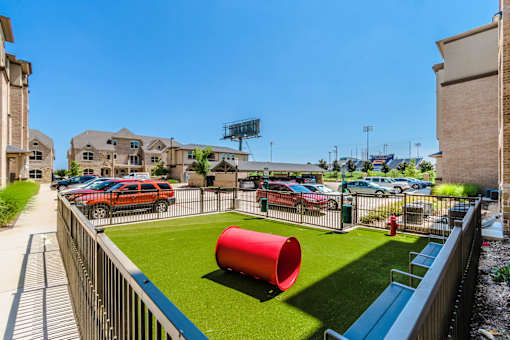 A red cylinder is in the middle of a grassy area at Atlas Point at Prestonwood Apartments , Texas, 75010