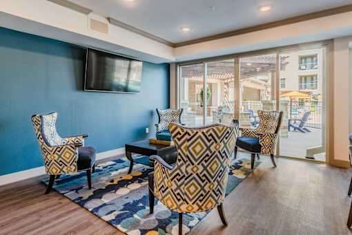 A living room with a blue wall and a television. at Atlas Point at Prestonwood Apartments , Texas, 75010