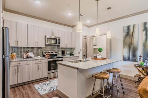 A kitchen with a white countertop and wooden floors. at Atlas Point at Prestonwood Apartments , Carrollton, 75010