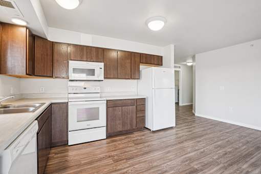 A kitchen with white appliances and wooden cabinets.