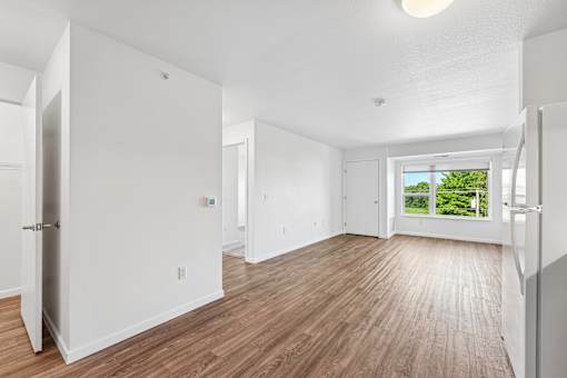 A large empty room with wooden floors and white walls.