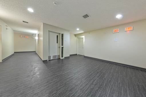 A long hallway with exit signs on the wall.
