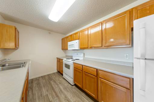 A kitchen with wooden cabinets and white appliances.