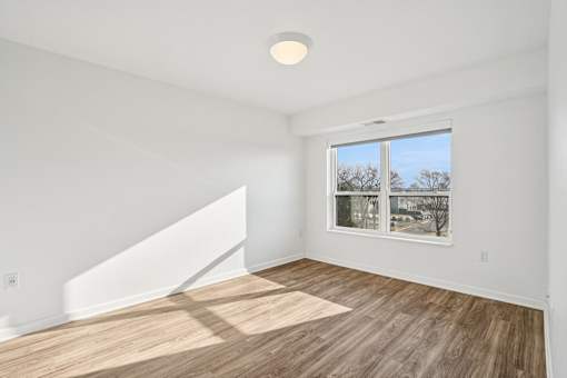 A room with a window and a wooden floor.