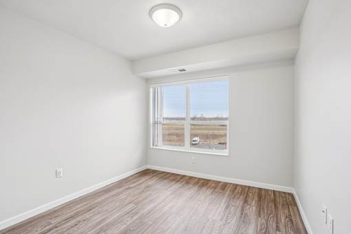 A room with a window showing a view of a construction site.