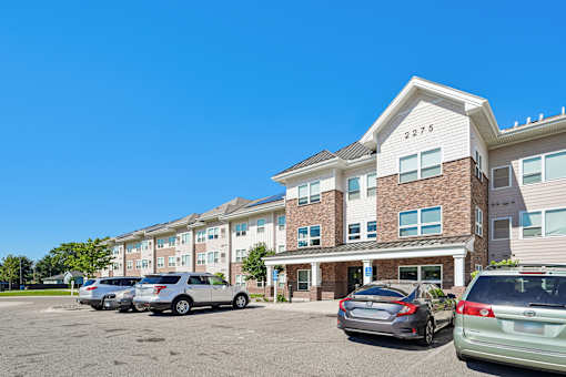Apartment building with cars parked in front.