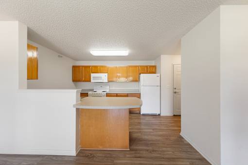 A kitchen with white appliances and wooden cabinets.