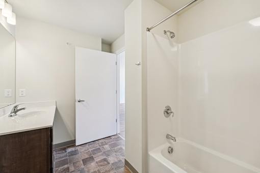 A white bathroom with a sink and a tub.