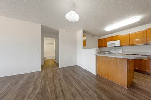 A kitchen with wooden cabinets and a white microwave.