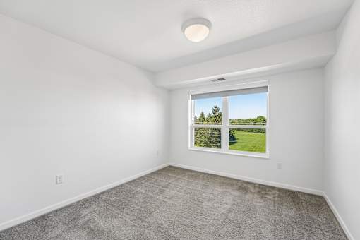 A room with a window showing a green landscape.
