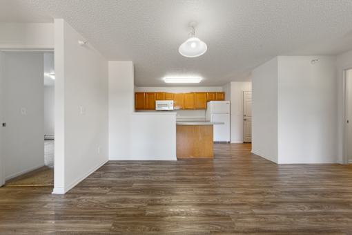 A kitchen with wooden floors and white walls.