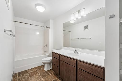 A bathroom with brown cabinets and a white sink.
