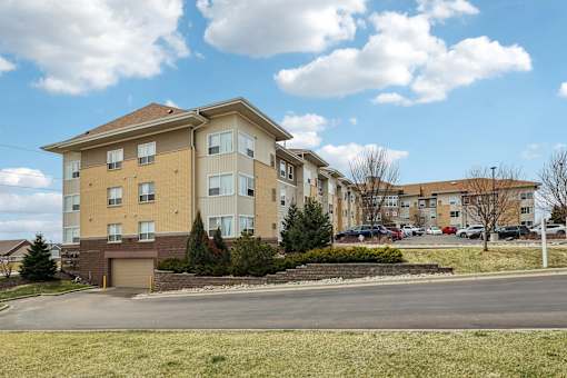 A large apartment building with a parking lot in front.