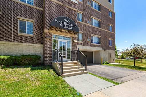 The front of a brick building with a sign that says "950 Washington Village".