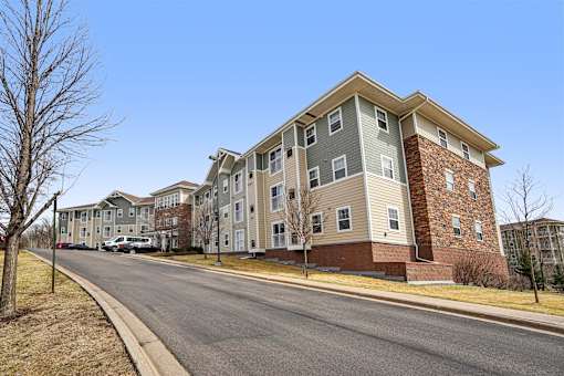 A street view of a residential area with apartment buildings on the side.