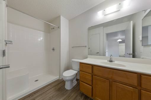 A white toilet sits in a bathroom next to a white sink.