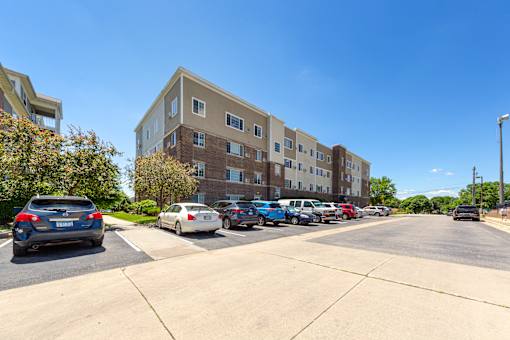 A parking lot with cars and apartment buildings in the background.
