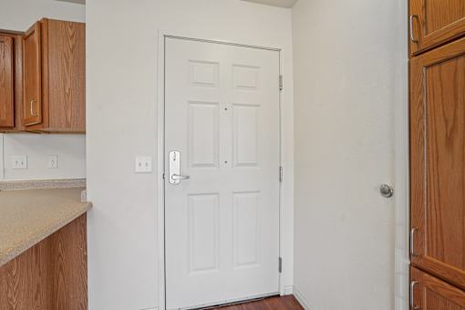 A white door with a silver handle is in the middle of a room.