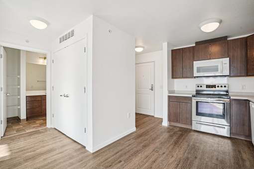 A kitchen with a white refrigerator, wooden cabinets, and a stainless steel stove.