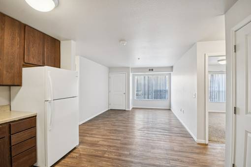 A kitchen with a white refrigerator and wooden cabinets.