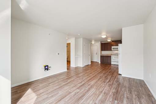 A room with a white wall and a brown floor.