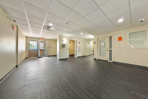 A long hallway with doors on both sides and a window on the right.