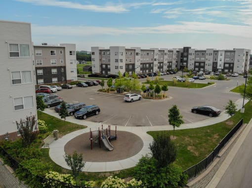 an aerial view of an apartment complex with cars in a parking lot