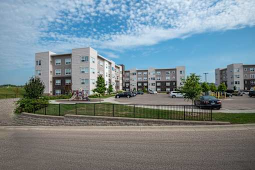 A large apartment complex with a playground in the front.