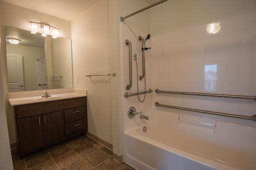 A bathroom with a white tub and a white sink.