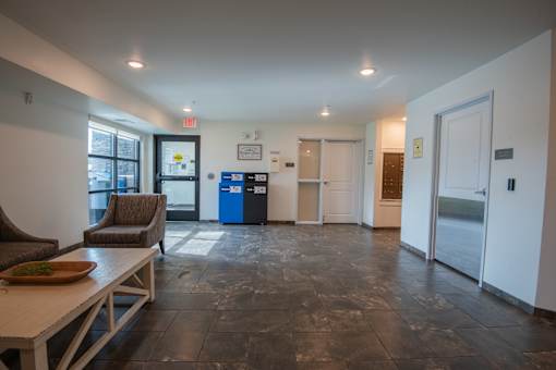 A room with a table and chairs and a recycling bin.