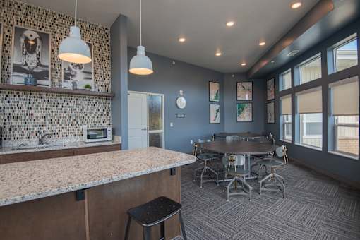 A kitchen with a bar area and a dining table.