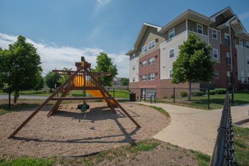 an empty playground with an apartment building in the background