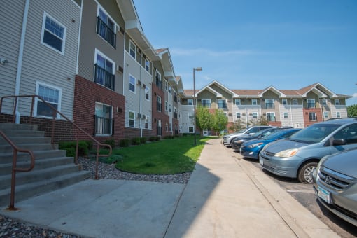 a row of cars parked in front of an apartment building