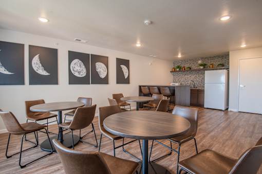 A room with a table and chairs and pictures of the moon on the wall.