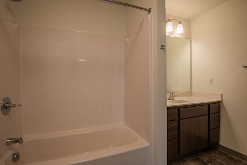 A white bathroom with a tub and sink.