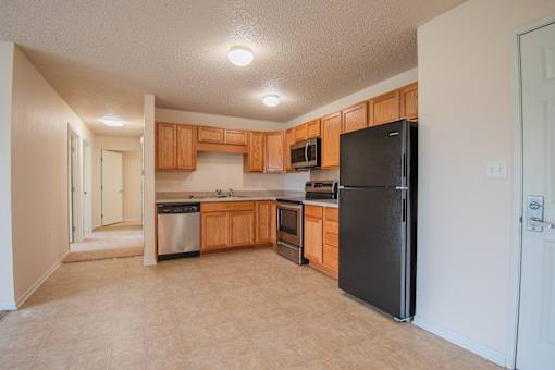 A kitchen with black appliances and wooden cabinets.