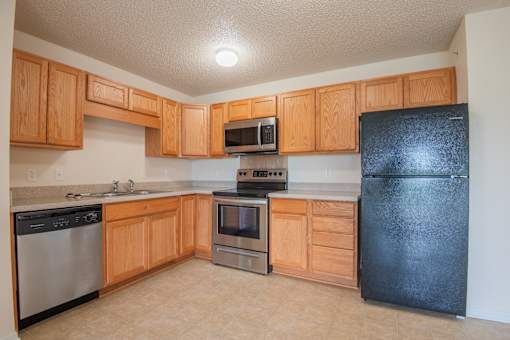 A kitchen with wooden cabinets and black appliances.