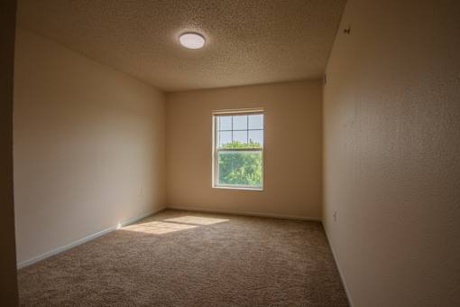 A room with a window and carpeted floor.