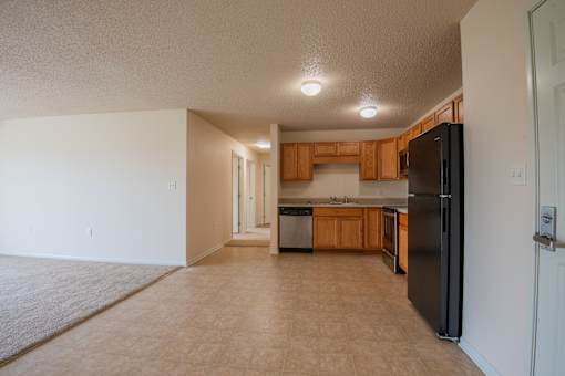 A kitchen with black appliances and wooden cabinets.
