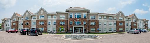 A large apartment complex with a parking lot in front.